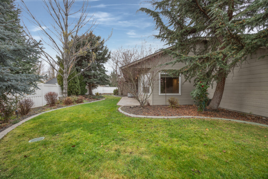 Backyard patio view featuring mature landscaping, stamped concrete patio, and hot tub at 2680 south loftus way in meridian, idaho listed by jeff sudmeier with idahoreal.estate team at action real estate.